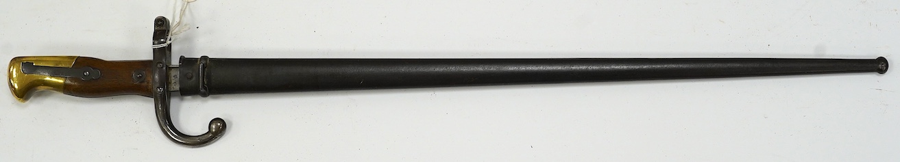 An 1875 French T-section bayonet in its steel scabbard for a Gras rifle, with engraving in French to the top of the blade. Condition - good